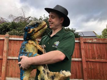 baby raptor baby dinosaur at party in keepers arms
